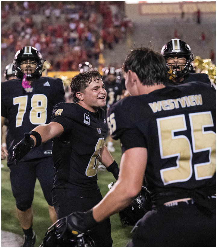 A group of football players wearing black and white uniforms. Description generated by AI