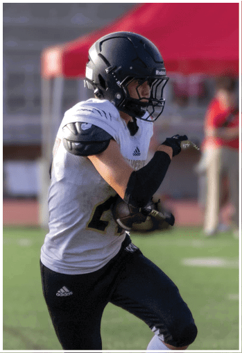 A football player running on the field. Description generated by AI