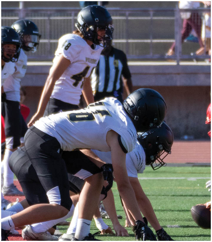 A group of football players wearing black and white uniforms. Description generated by AI