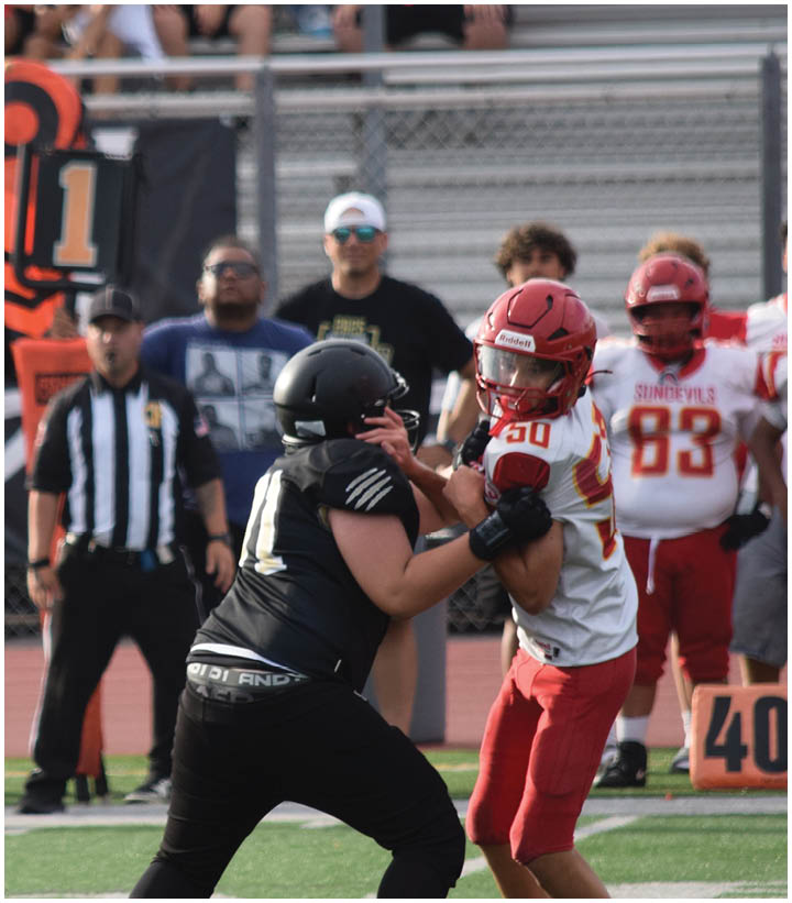 A group of football players wearing black and white uniforms. Description generated by AI