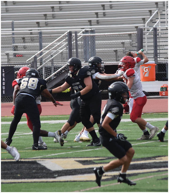 A group of football players wearing black and white uniforms. Description generated by AI