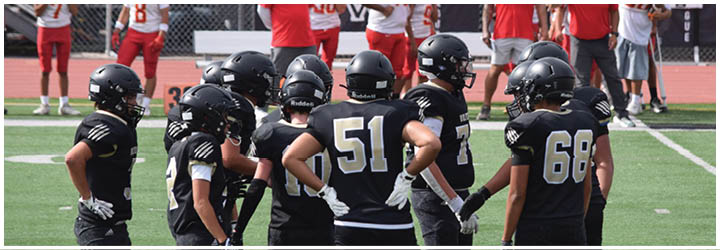 A group of football players on a field. Description generated by AI