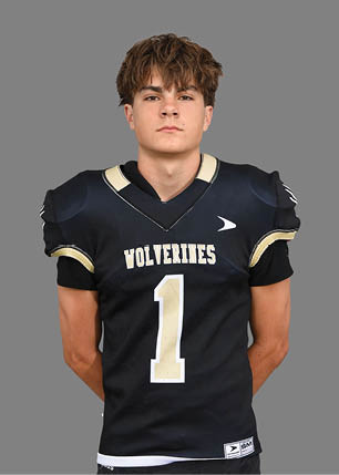 A young man wearing a white and black jersey with the number 14 on it. Description generated by AI