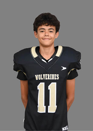 A young man wearing a white and black jersey with the number 14 on it. Description generated by AI
