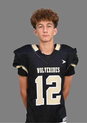 A young man wearing a white and black jersey with the number 14 on it. Description generated by AI