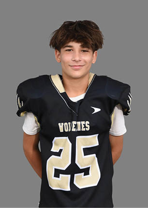 A young man wearing a white and black jersey with the number 14 on it. Description generated by AI