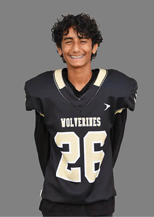 A young man wearing a white and black jersey with the number 14 on it. Description generated by AI