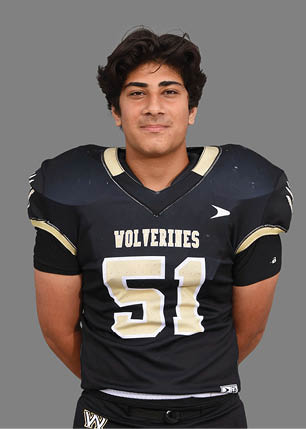 A young man wearing a white and black jersey with the number 14 on it. Description generated by AI