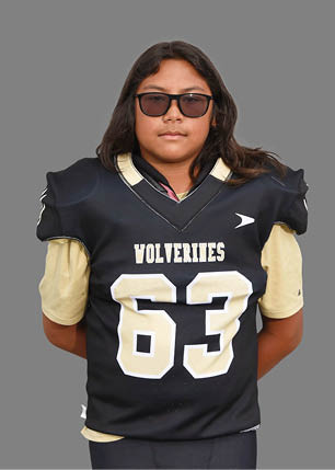 A young man wearing a white and black jersey with the number 14 on it. Description generated by AI