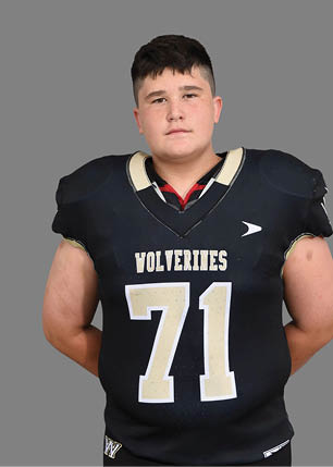 A young man wearing a white and black jersey with the number 14 on it. Description generated by AI