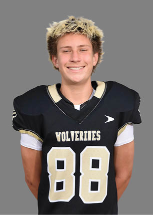 A young man wearing a white and black jersey with the number 14 on it. Description generated by AI