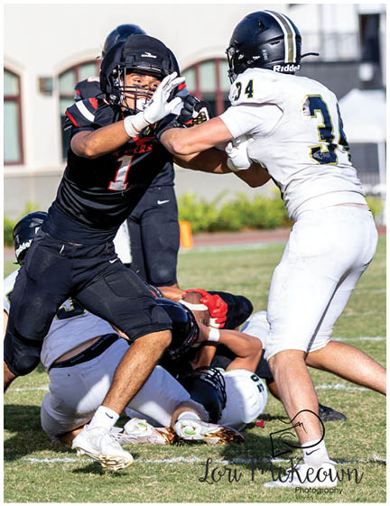 A football player wearing a blue and red jersey. Description generated by AI