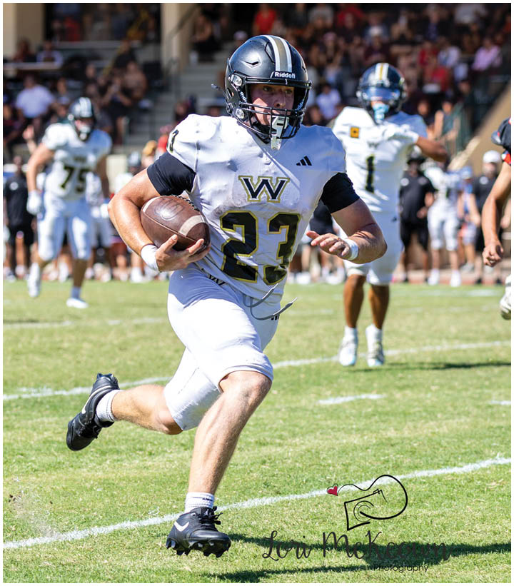 A group of football players wearing black and white uniforms. Description generated by AI