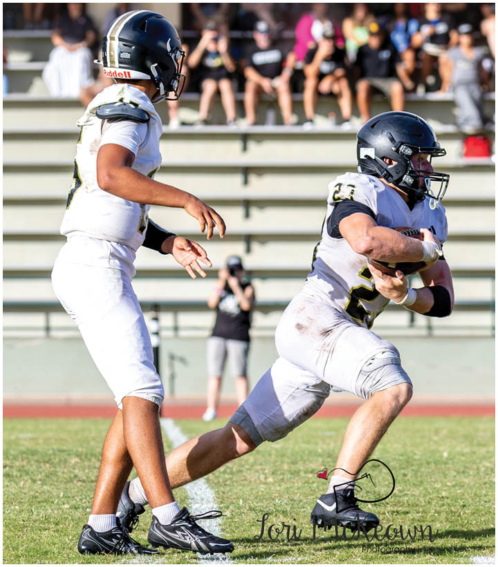 A group of football players wearing black and white uniforms. Description generated by AI