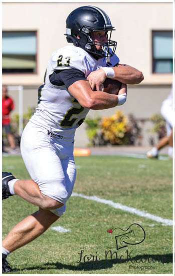 A football player running on the field. Description generated by AI