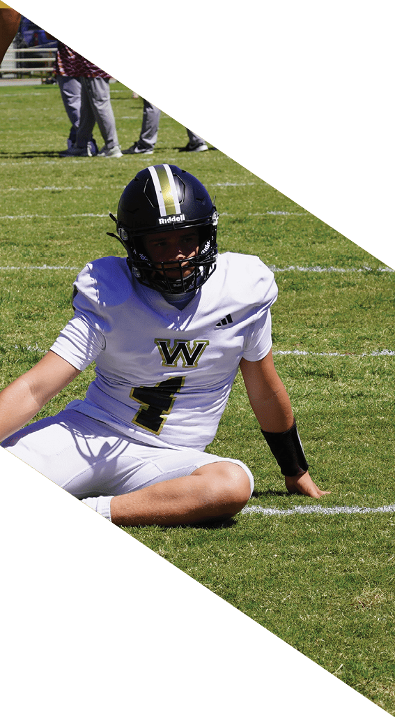 A football player wearing a black helmet and white jersey is holding a football in his hands. AI generated content
