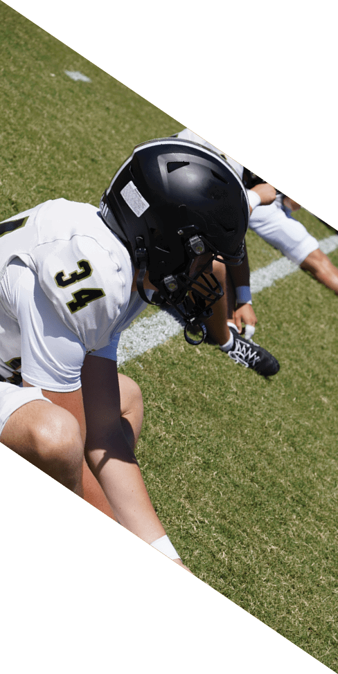 Two men are jumping in the air on a field, both wearing football uniforms. AI generated content