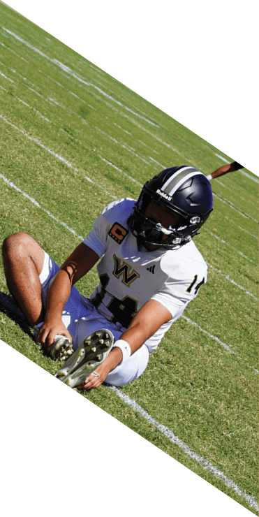 Two football players are on the field, one jumping in the air while the other is running. A referee is also present, watching the play. AI generated content