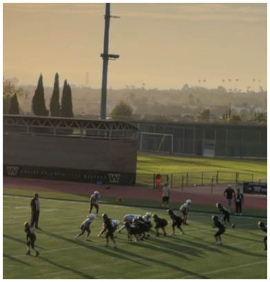 Two men embrace on a field, one wearing a black shirt and the other wearing a black and white shirt. AI generated content