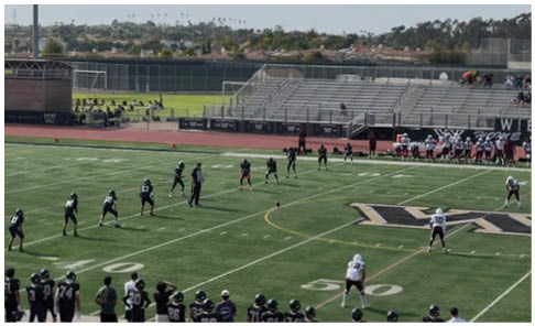 Two men wearing football uniforms are hugging each other on a field. AI generated content