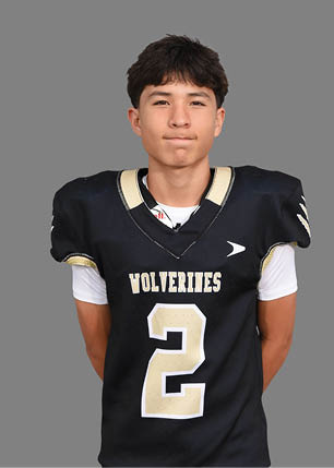 A young man wearing a white and black jersey with the number 14 on it. Description generated by AI