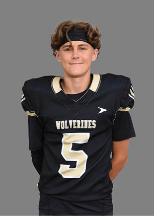 A young man wearing a white and black jersey with the number 14 on it. Description generated by AI