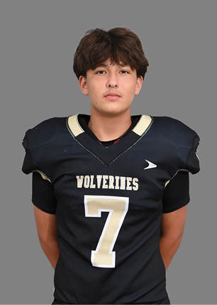 A young man wearing a white and black jersey with the number 14 on it. Description generated by AI