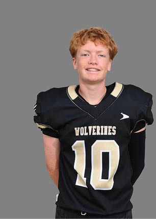 A young man wearing a white and black jersey with the number 14 on it. Description generated by AI