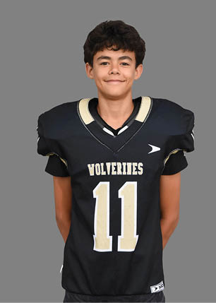 A young man wearing a white and black jersey with the number 14 on it. Description generated by AI