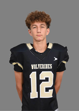 A young man wearing a white and black jersey with the number 14 on it. Description generated by AI