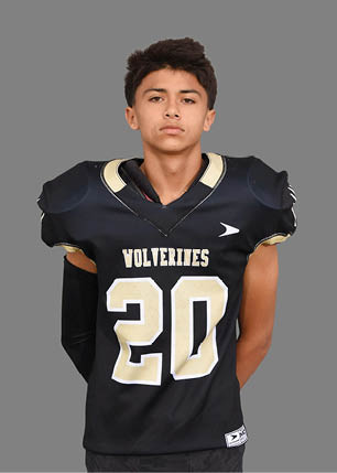 A young man wearing a white and black jersey with the number 14 on it. Description generated by AI