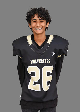 A young man wearing a white and black jersey with the number 14 on it. Description generated by AI
