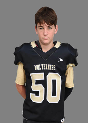 A young man wearing a white and black jersey with the number 14 on it. Description generated by AI