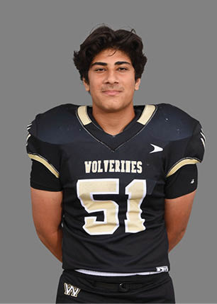 A young man wearing a white and black jersey with the number 14 on it. Description generated by AI