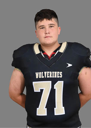 A young man wearing a white and black jersey with the number 14 on it. Description generated by AI