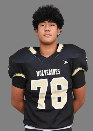 A young man wearing a white and black jersey with the number 14 on it. Description generated by AI