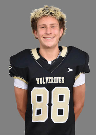 A young man wearing a white and black jersey with the number 14 on it. Description generated by AI