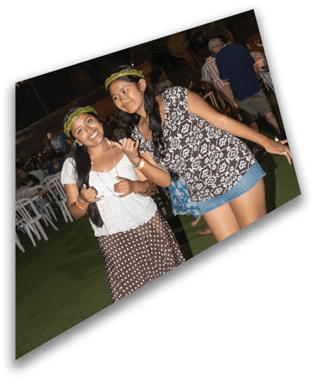 A group of people wearing black football uniforms with helmets are gathered on a field at night, with some of them interacting closely. Description generated by AI