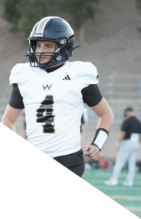 A football player is kneeling on the field, holding his helmet in his hands. AI generated content