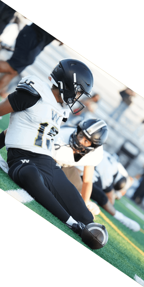 Two men are jumping in the air on a field, both wearing football uniforms. AI generated content