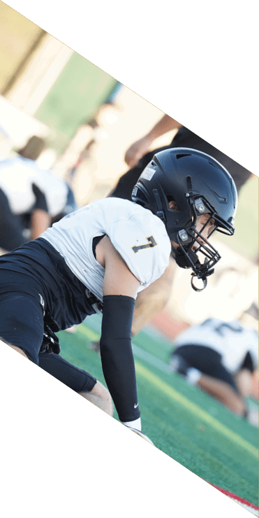 Two football players are on the field, one jumping in the air while the other is running. A referee is also present, watching the play. AI generated content