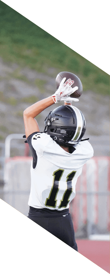 A football player wearing a white jersey with the number 86 catches a football in the air. AI generated content