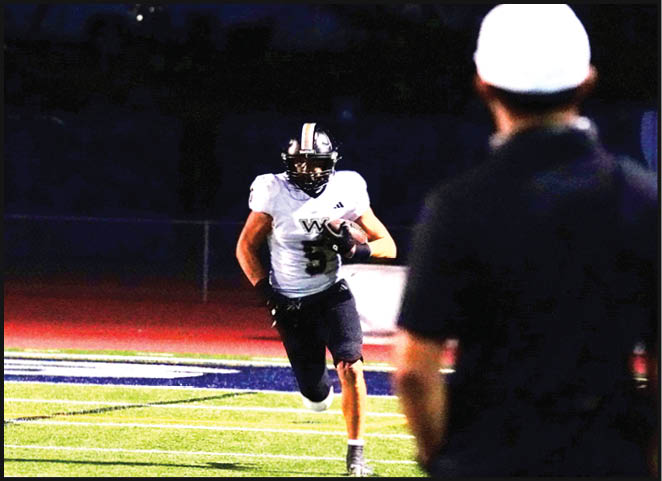 A group of football players in black and white uniforms are on the field. AI generated content