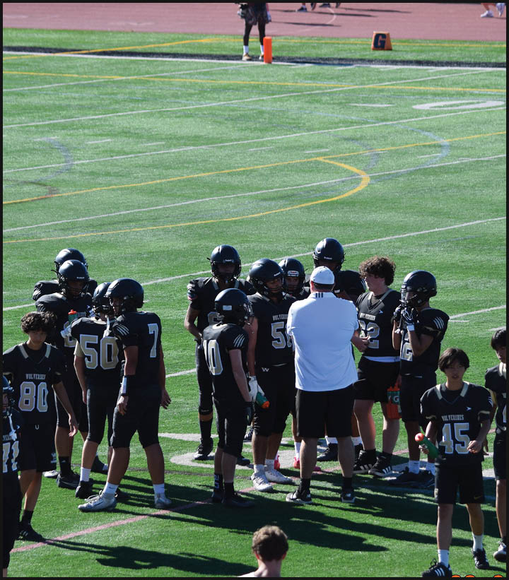 A group of football players wearing black and white uniforms. Description generated by AI