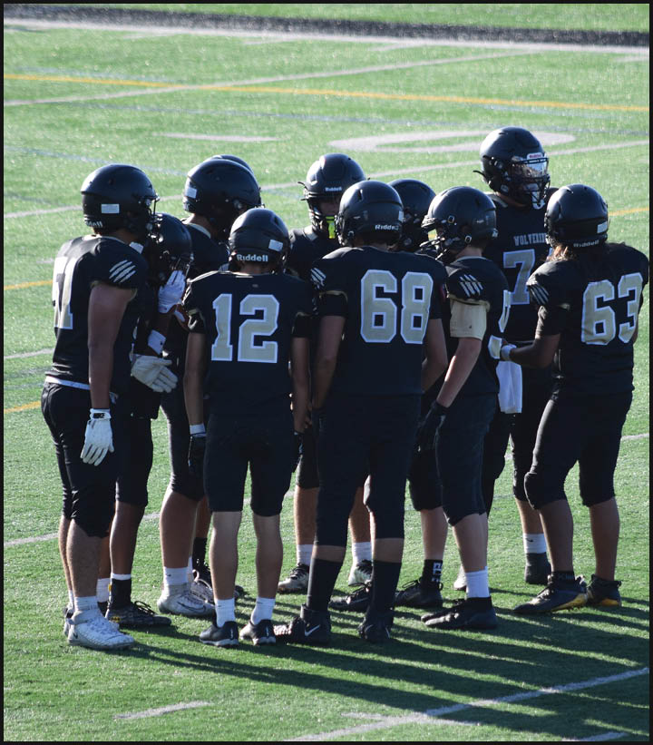 A group of football players wearing black and white uniforms. Description generated by AI