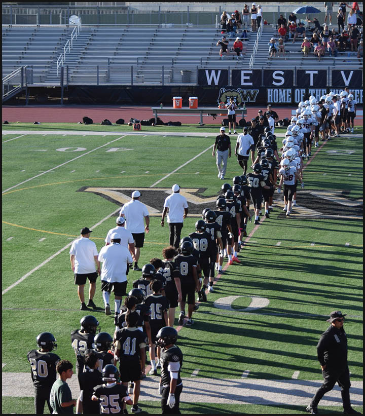 A group of football players wearing black and white uniforms. Description generated by AI