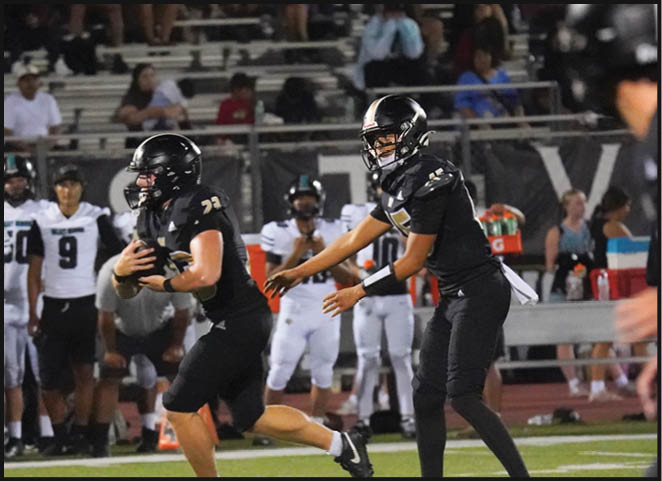 A group of football players in black and white uniforms are on the field. AI generated content