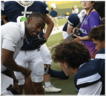 A football game is taking place with a group of men on the field. Description generated by AI