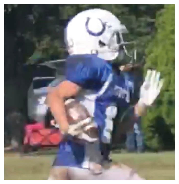 A football player wearing a blue and red jersey. Description generated by AI
