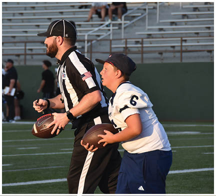 A football game is taking place with a group of men on the field. Description generated by AI